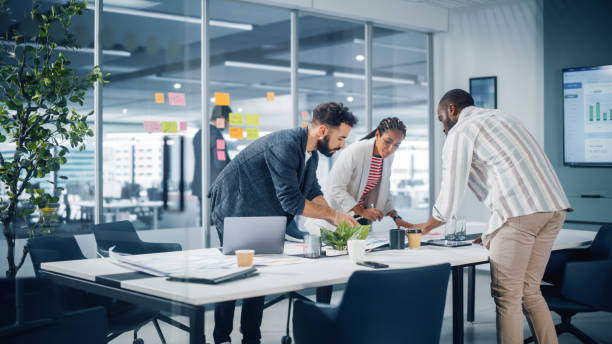 Diverse Team of Professional Businesspeople Meeting in the Office Conference Room. Creative Team Around Table, Black Businesswoman, African-American Digital Entrepreneur and Hispanic CEO Talking.